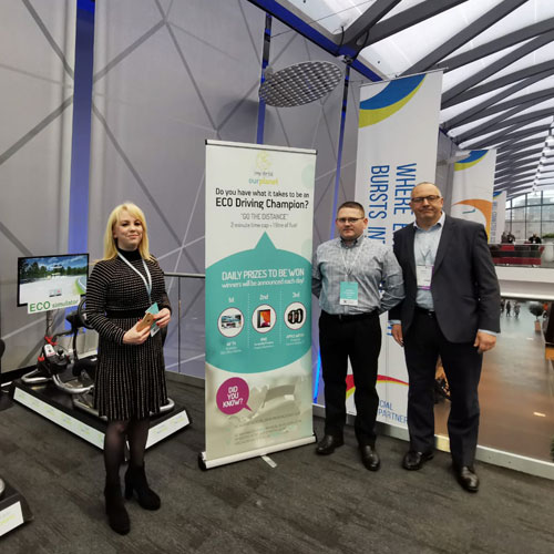 The LMS Eco driving simulator on an exhibition stand with an Eco Driving Champion banner