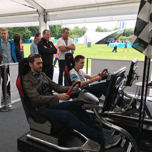 Two guests driving LMS simulators side by side at an outdoor event