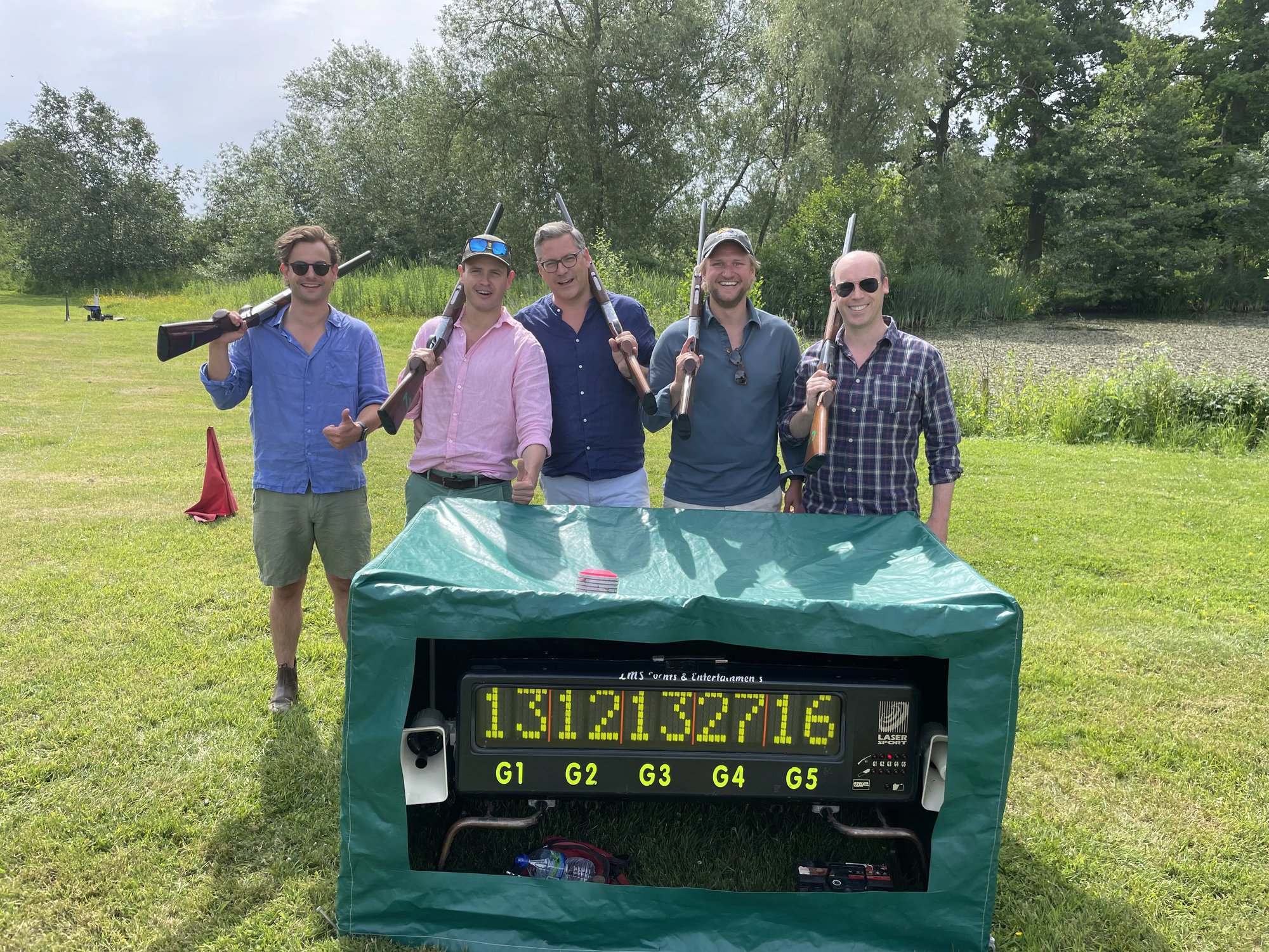 Group with shotguns beside the LMS laser clay scoreboard